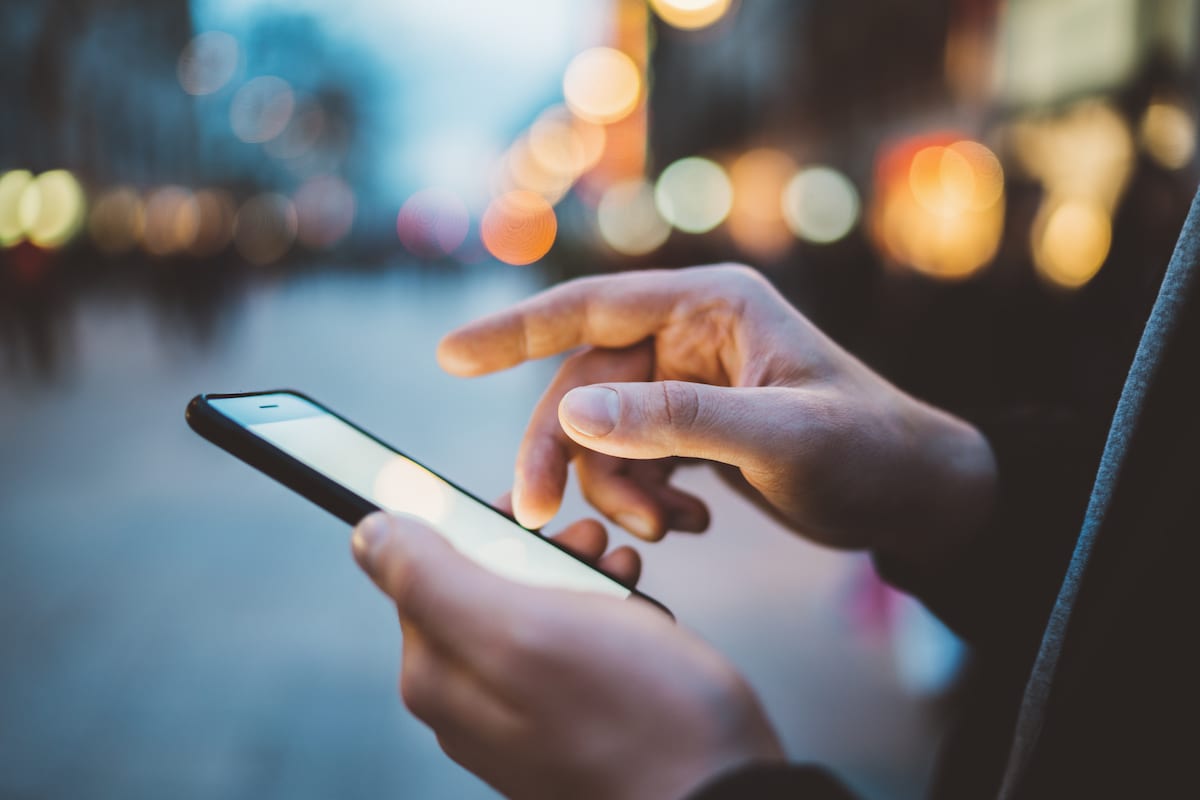 Google Lead Form Ads Person searching internet on mobile phone
