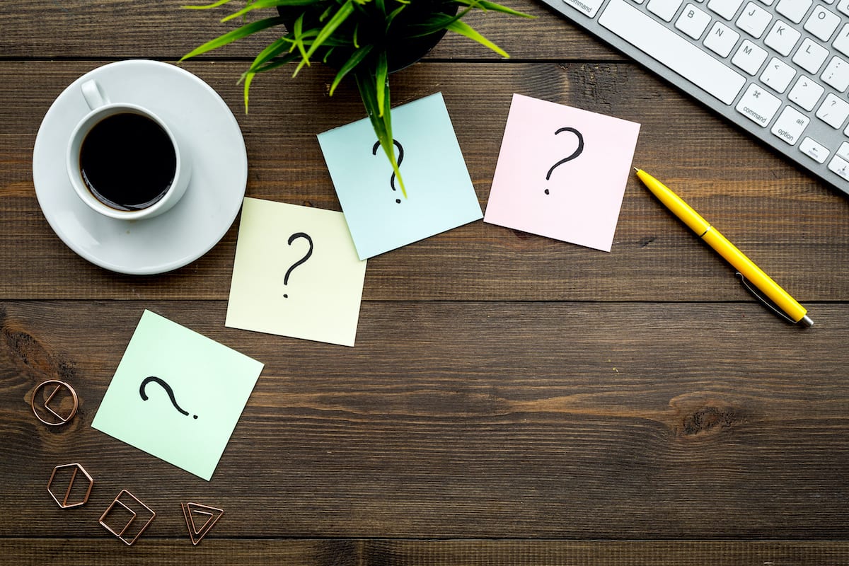 Learn more about optimizing your FAQ page! Question marks on sticky notes representing frequently asked questions